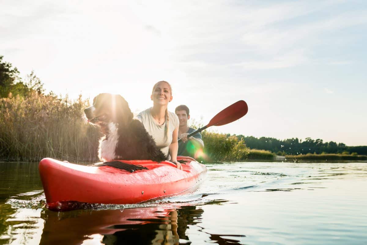 Woman enjoying the ride on kayak with dog and her husband