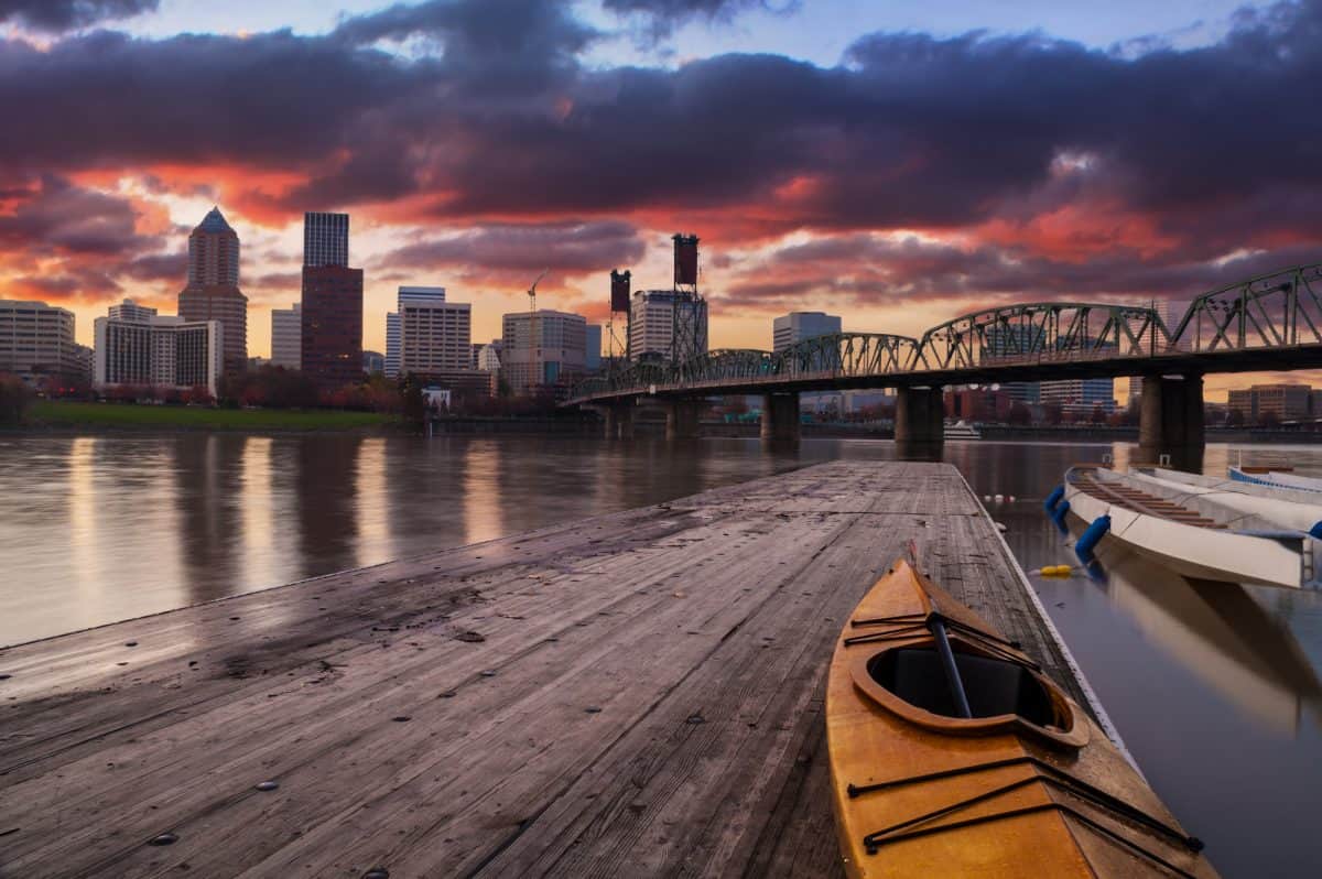 Kayaking at night. Portland, Oregon Panorama. Sunset scene with dramatic sky and light reflections on the Willamette River.