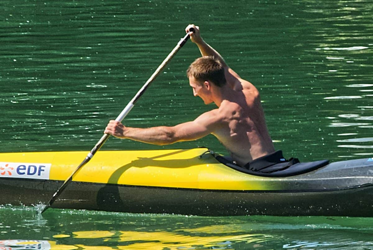 Topless man with Muscle paddling kayak