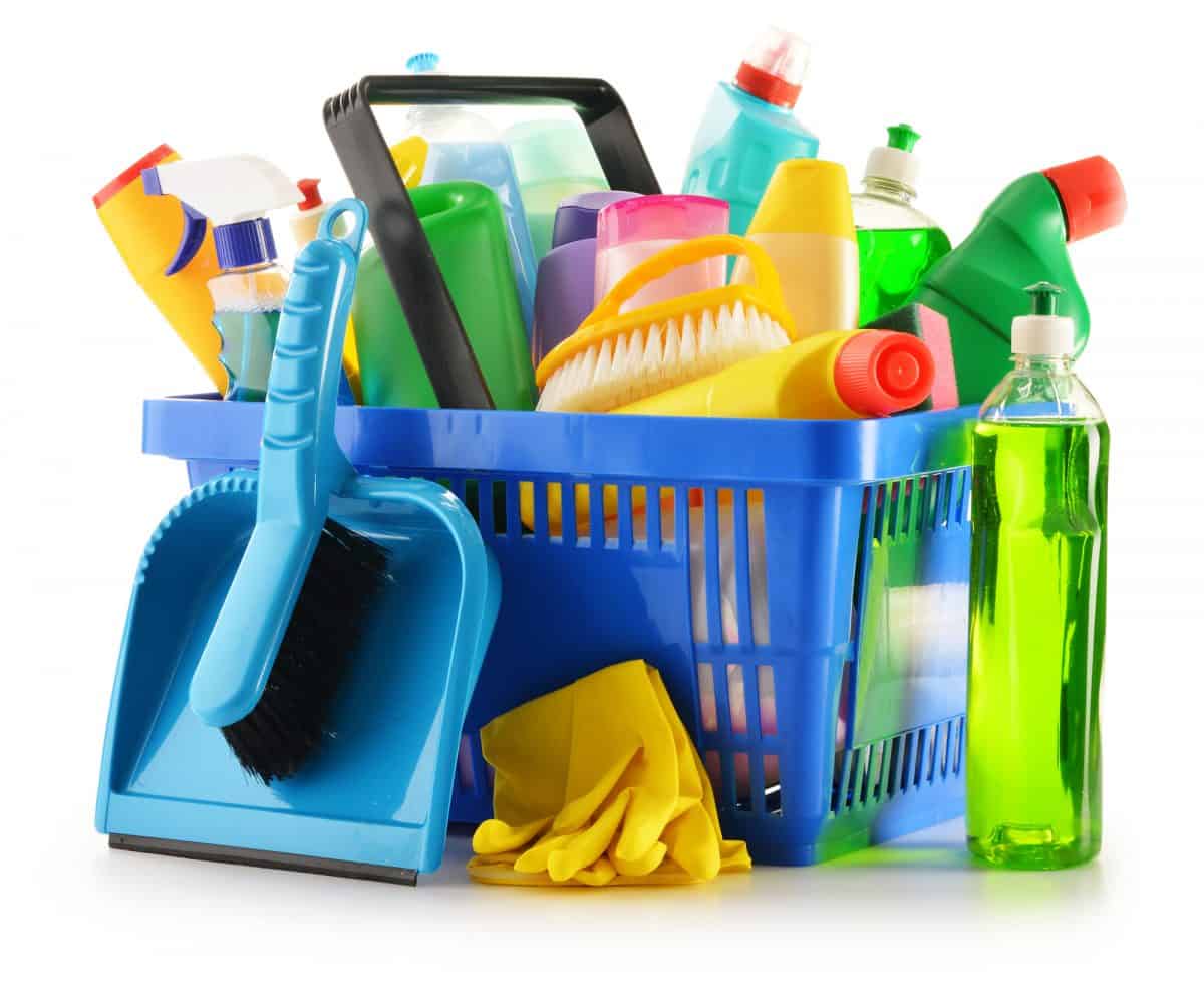 hopping basket with detergent bottles and chemical cleaning supplies isolated on white