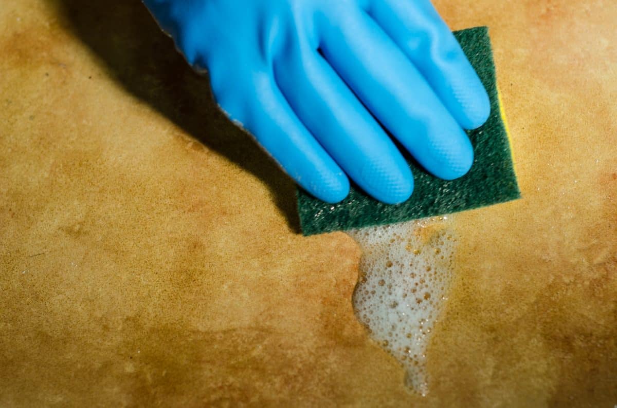 hands in rubber gloves cleaning the surfaces of kayak