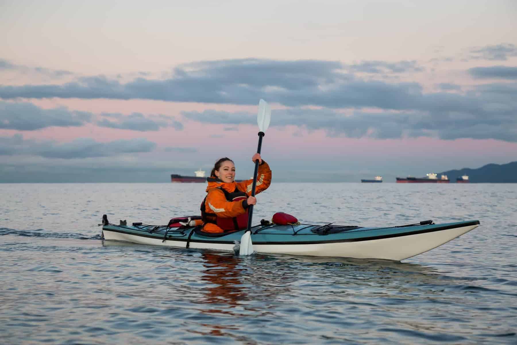 woman paddling  blue sea kayak with kayak rudder