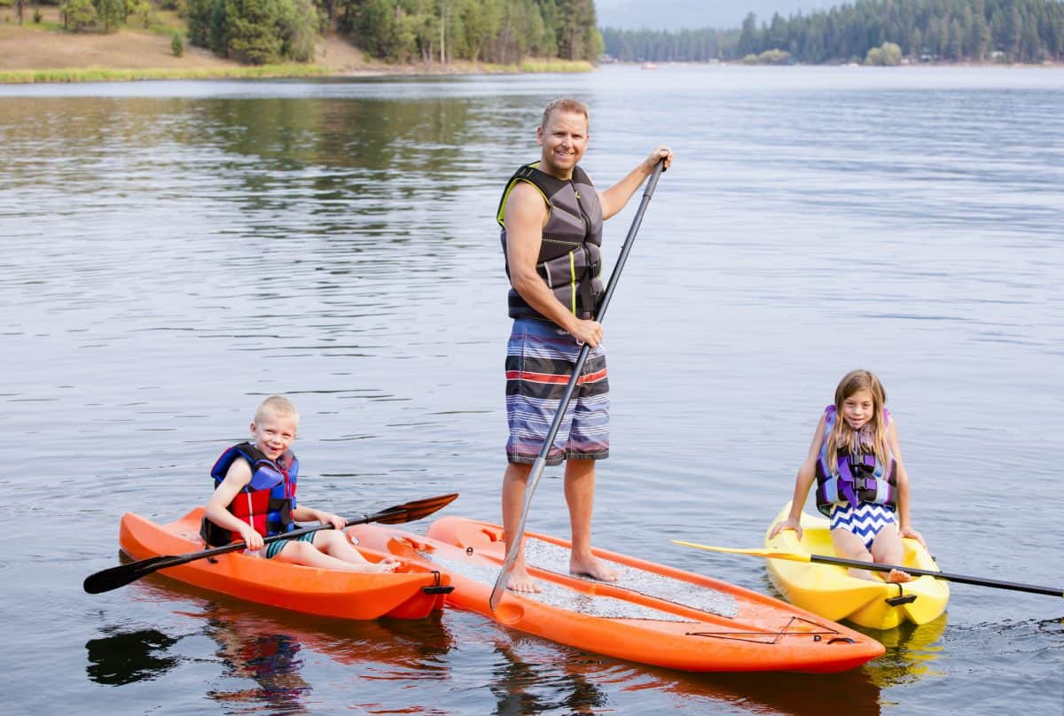 father on SUP and two child in kayaks 