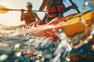 Two kayakers demonstrate how to paddle a tandem kayak